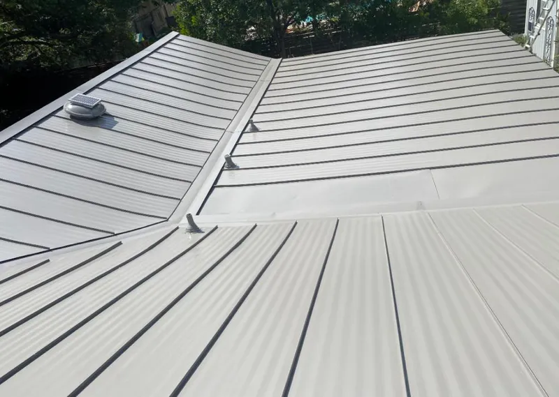 Solar attic fan installed on a metal roof for Roof Ventilation in Attica